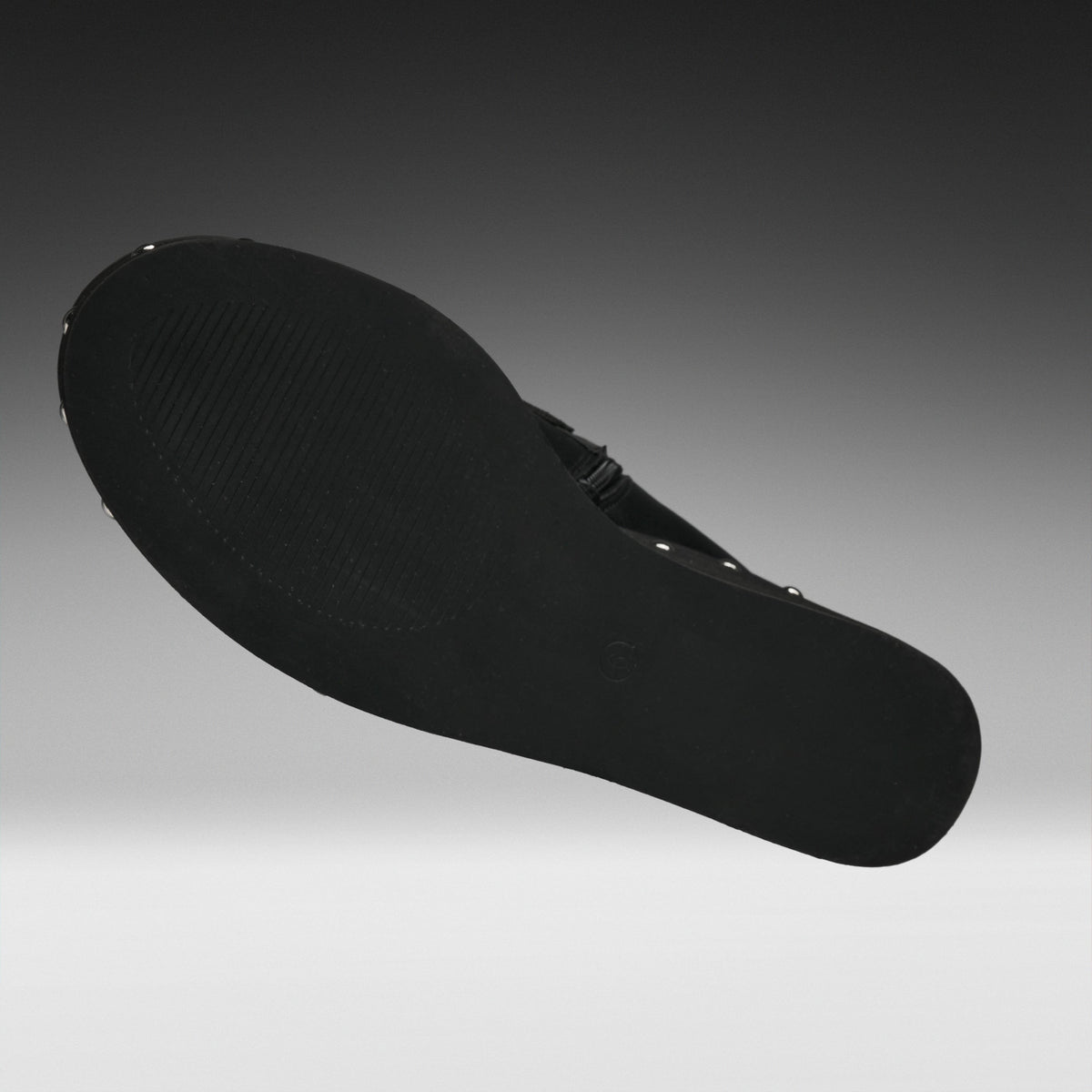 A black shoe sole shown floating against a gradient gray background.