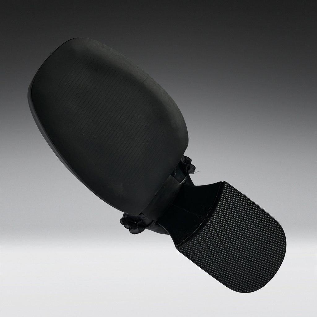 A black car side-view mirror assembly with a textured plastic housing and a mesh-covered mounting bracket, shown against a dark-to-light gray gradient studio background.