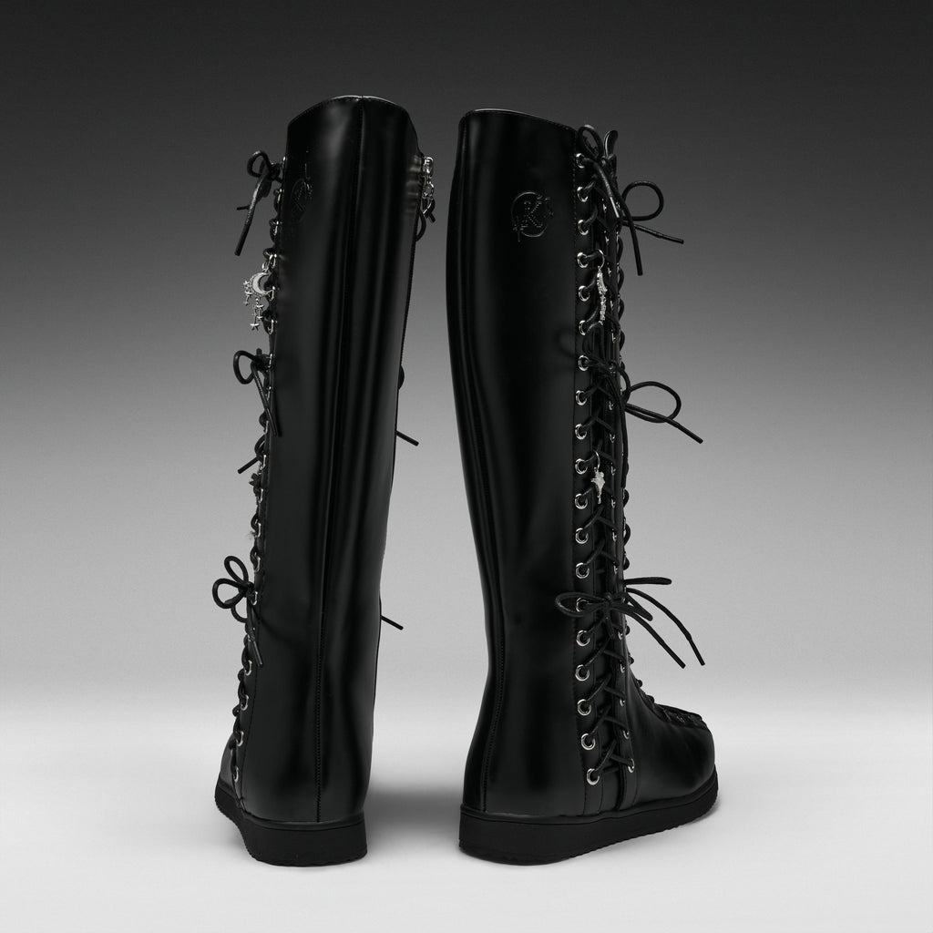 A pair of black knee-high lace-up boots shown from the back on a dark-to-light gray gradient studio background.
