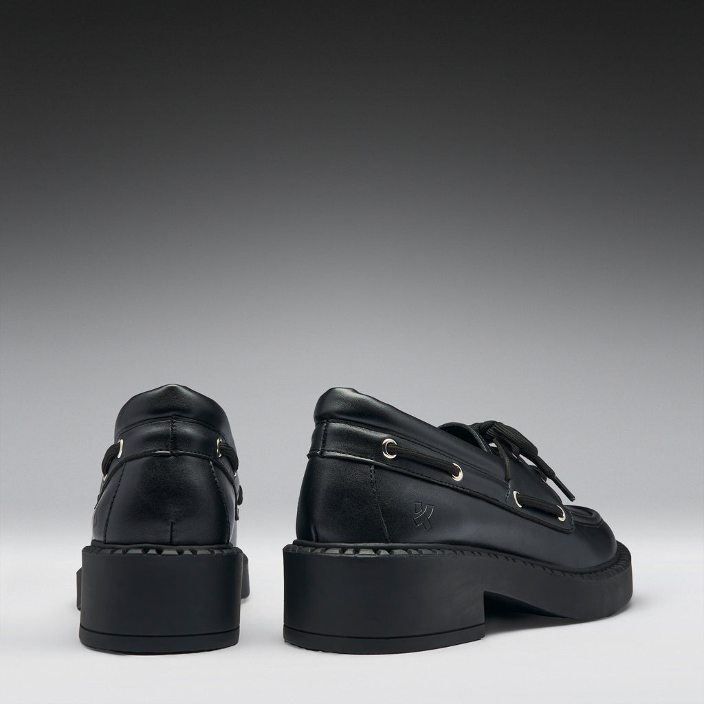 Pair of black leather shoes on a gray background