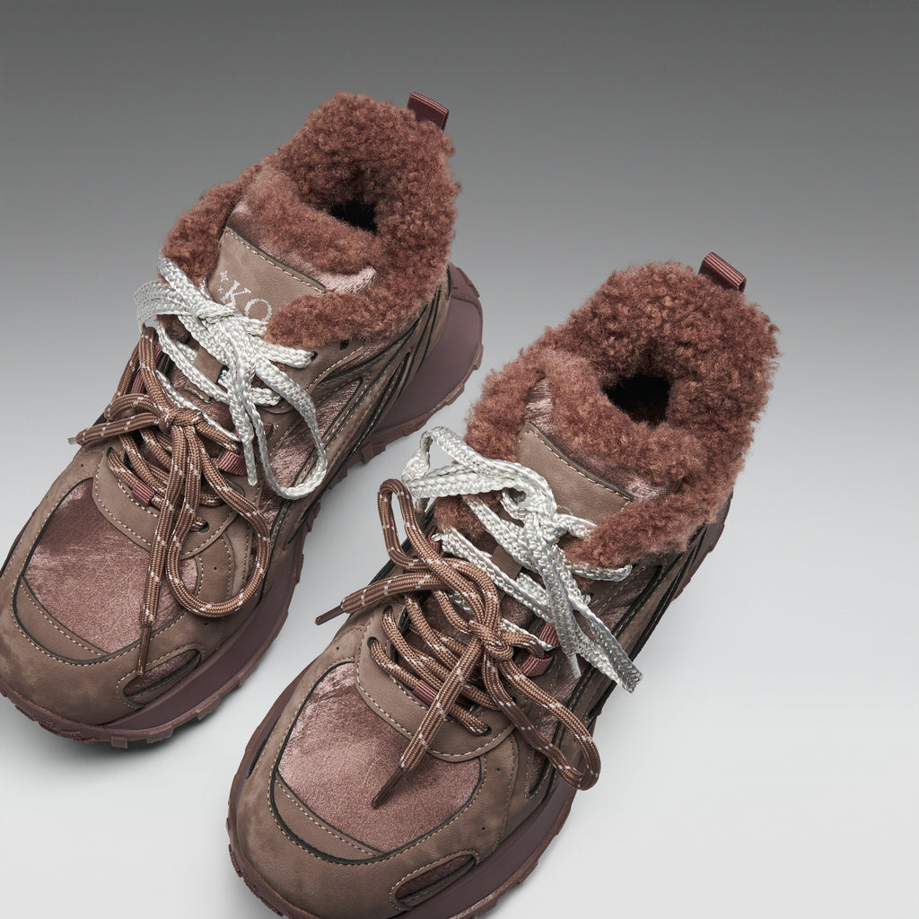 Pair of brown winter boots with fur lining on a light gray background